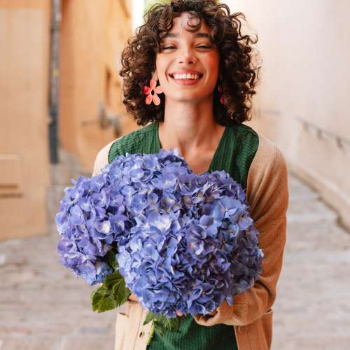 ragazza che tiene un mazzo di ortensie viola
